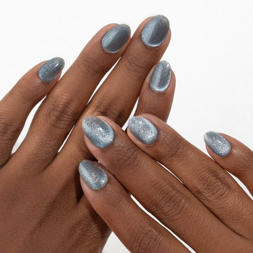 Two hands with light blue nail polish on a white background