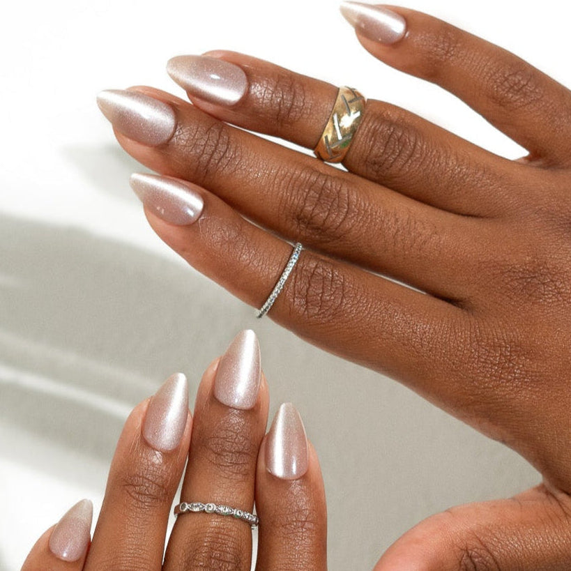 cat eye press on nails with gold rings and light nail polish on a white background