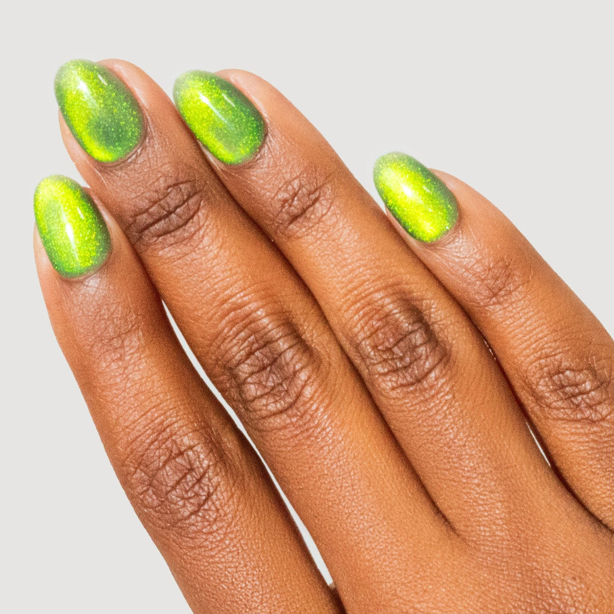 Hand with green nail polish on a light gray background