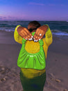 Person in a yellow jacket and green bag on a beach at sunset blue cat eye press on nails